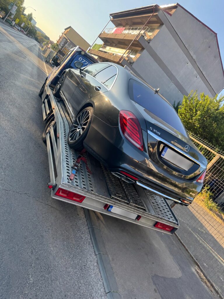 Mercedes S 350 încărcat pe o platformă auto într-o zonă urbană